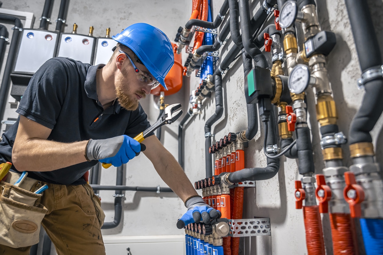 A commercial plumber checks the heating system in the boiler room of a commercial building in Atlanta.